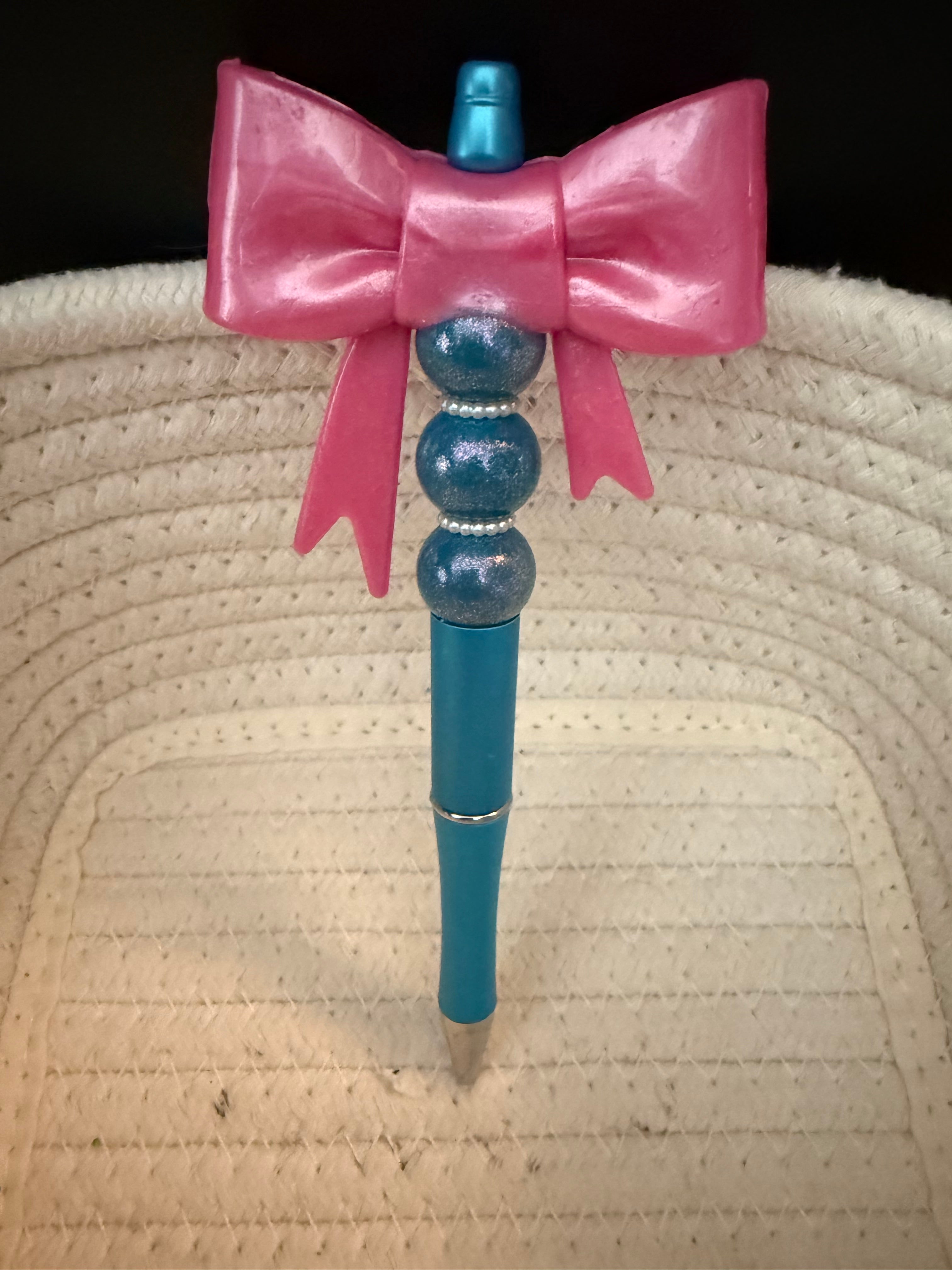 Large pink bow and  teal ink pen